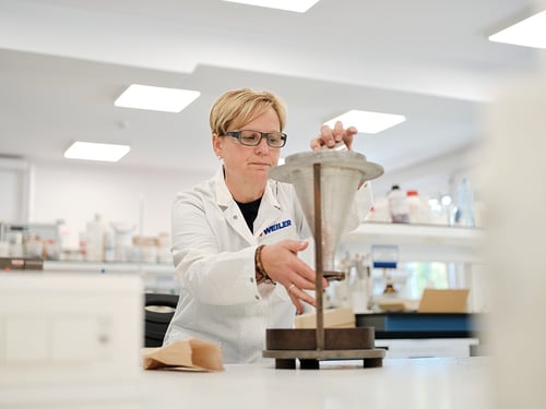 Weiler co-worker in a lab measuring abrasive grains